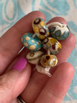 Set of 6 Handcrafted Lampwork Glass Beads in ivory, turquoise, browns, and golden yellow.